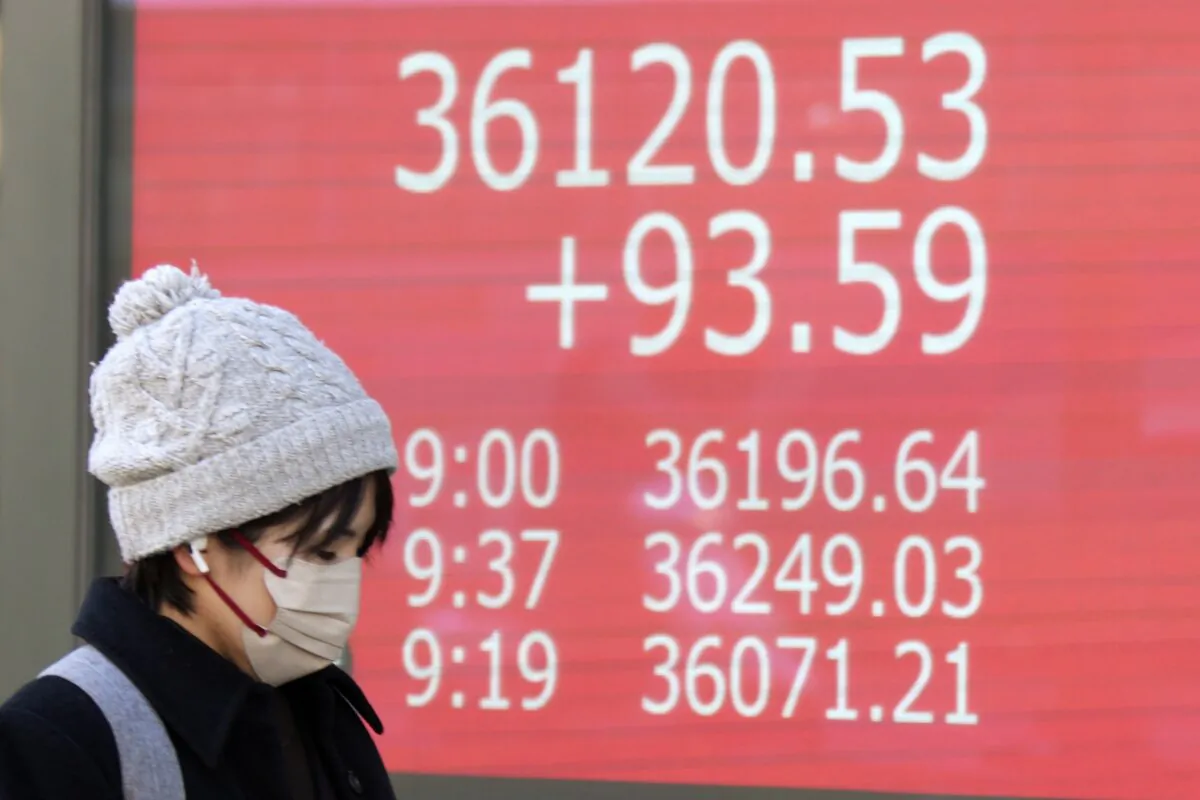 A person walks in front of an electronic stock board showing Japan's Nikkei 225 index at a securities firm in Tokyo on Jan. 30, 2024. (Eugene Hoshiko/AP Photo)