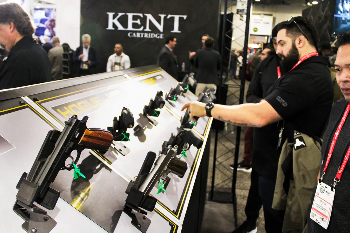 Attendees check out pistols on display at the Shooting, Hunting, Outdoors Trade (SHOT) Show, on Jan. 23, 2024 in Las Vegas, Nevada. (Michael Clements/The Epoch Times)
