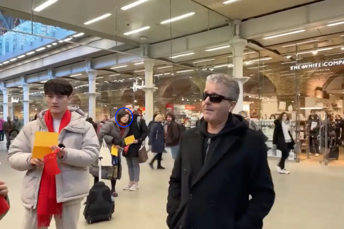 Screenshot of live streamed footage showing Christine Lee (circled) looking on 
 after Newton Leng (off screen) shouted at pianist Brendan Kavanagh (R) at St Pancras International station in London on Jan. 19, 2024. (Brendan Kavanagh/YouTube screenshot)