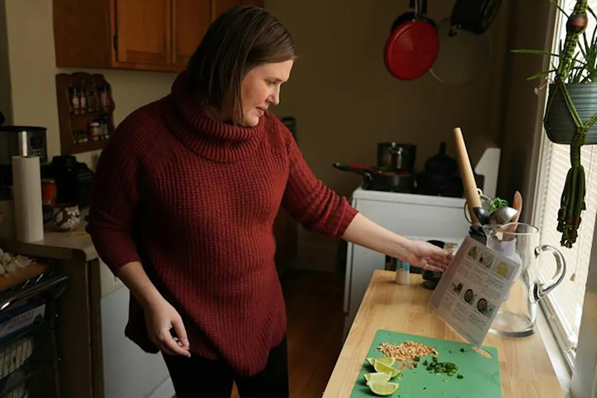 Jessica Bergman, a longtime Marley Spoon user, prepares one of their meal kits of stir-fried curry rice noodles with Chinese broccoli and peanuts for lunch as she worked from home. (Anthony Souffle, Star Tribune/TNS)