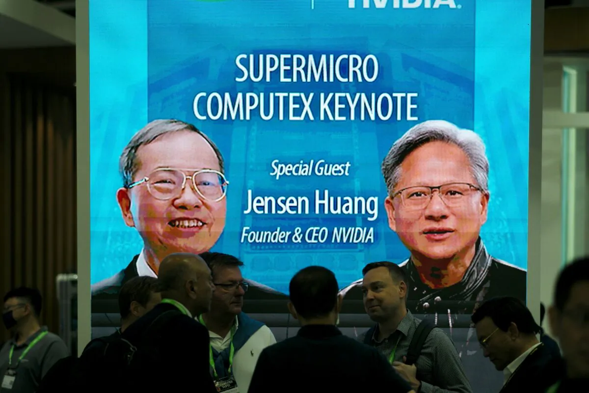Visitors are seen in front of a screen showing the images of Jensen Huang (R), CEO of NVIDIA, and Charles Liang, Founder and President of the Supermicro, at the Computex 2023 in Taipei on May 30, 2023. (Sam Yeh/AFP via Getty Images)