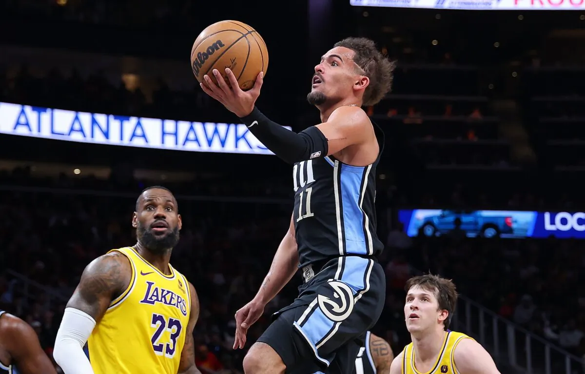 Trae Young (11) of the Atlanta Hawks drives against LeBron James (23) and Austin Reaves (15) of the Los Angeles Lakers during the third quarter in Atlanta on Jan. 30, 2024. (Kevin C. Cox/Getty Images)