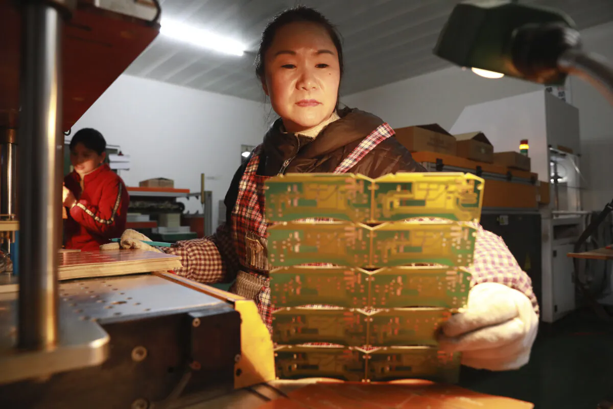 A woman works at a factory of printed circuit board in Hangzhou in eastern China's Zhejiang province on Jan. 7, 2024. (Chinatopix via AP)
