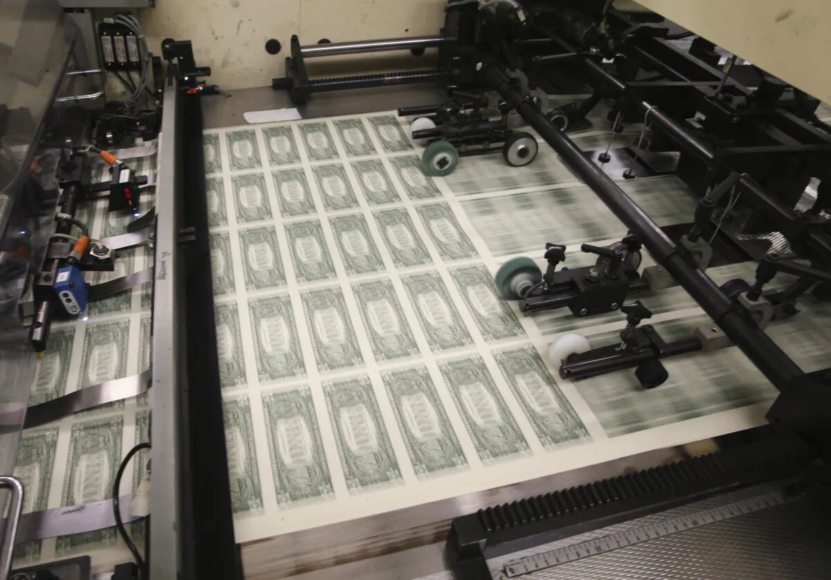 Sheets of one dollar bills run through the printing press at the Bureau of Engraving and Printing in Washington, D.C., on March 24, 2015. (Mark Wilson/Getty Images)