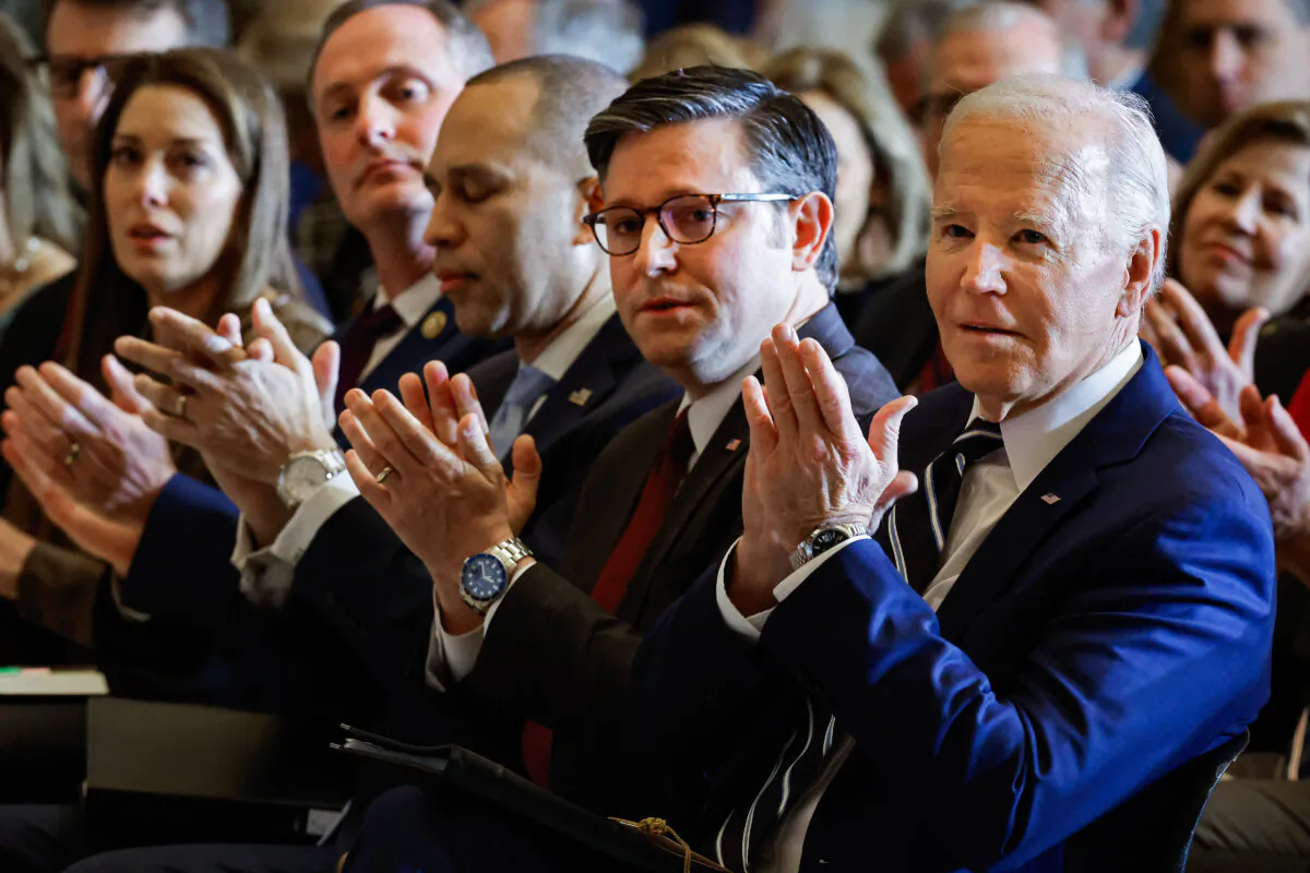 President Joe Biden, seated next to House speaker Mike Johnson (R-La.), applauds for Andrea Bocelli after the singer performed during the National Prayer Breakfast in Statuary Hall at the U.S. Capitol in Washington on Feb. 1, 2024. (Chip Somodevilla/Getty Images)