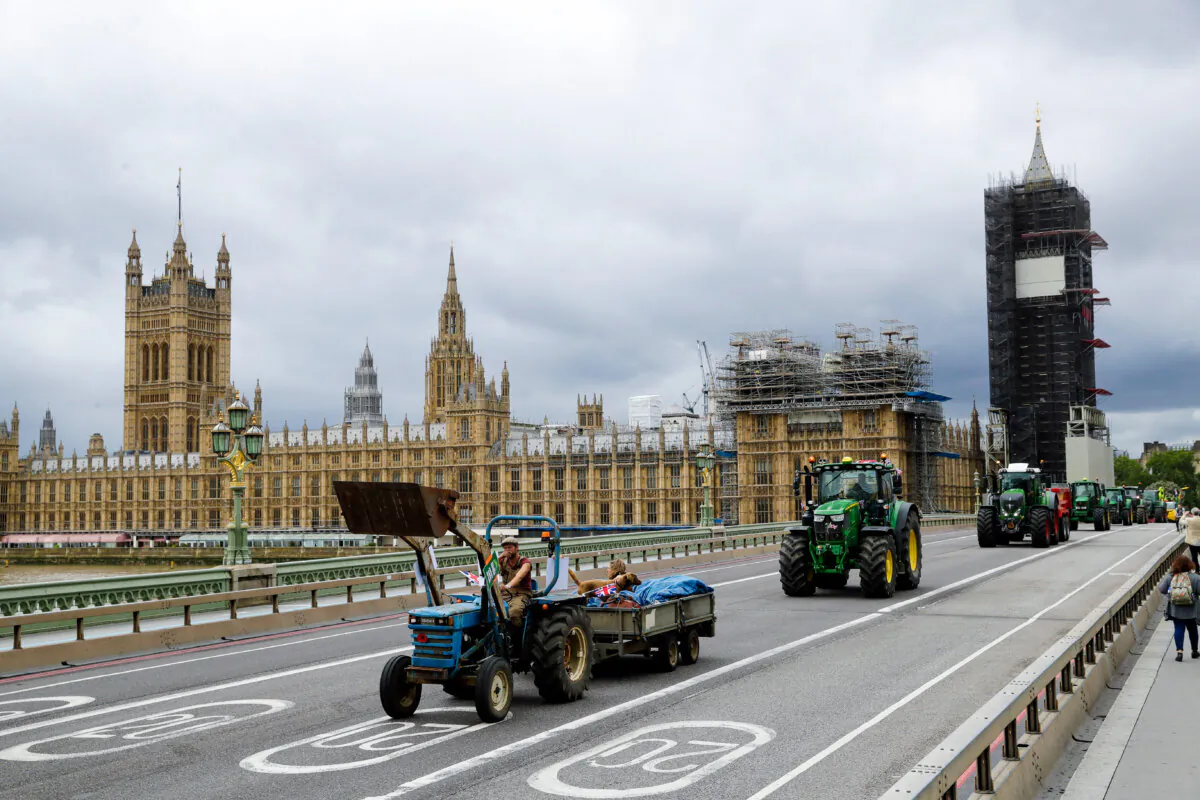 Farmers from the group Save British Farming drive tractors across Westminster Bridge, backdropped by the Houses of Parliament and the scaffolded Big Ben tower in London, in a protest against cheaply produced lower standard food being imported from the U.S. after Brexit that will undercut them on July 8, 2020. (Matt Dunham/AP)