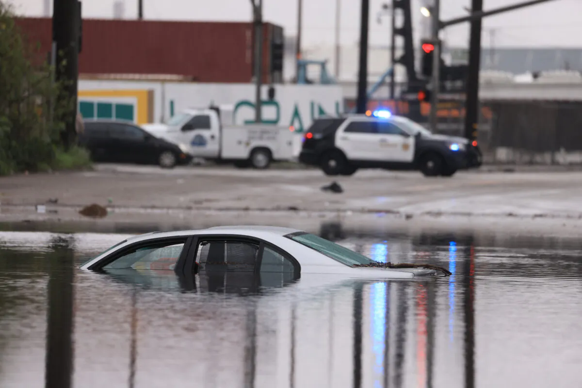 A car sits partially submerged on a flooded road during a rain storm in Long Beach, Calif., on Feb. 1, 2024. (David Swanson/AFP via Getty Images)