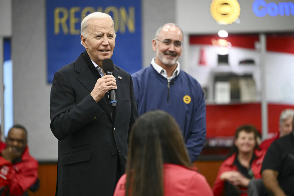 US President Joe Biden speaks to members of the United Auto Workers (UAW) at the UAW National Training Center, in Warren, Michigan, on February 1, 2024 as UAW president Shawn Fain looks on. US President Joe Biden is in Michigan to attend campaign events. (Photo by Mandel NGAN / AFP)