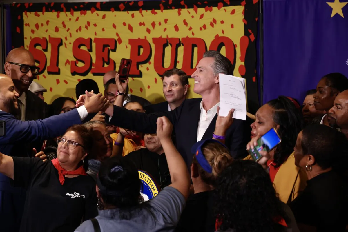 California Gov. Gavin Newsom signs the fast food bill surrounded by fast food workers at the SEIU Local 721 in Los Angeles on Sept. 28, 2023. (Courtesy of Office of Governor Gavin Newsom)