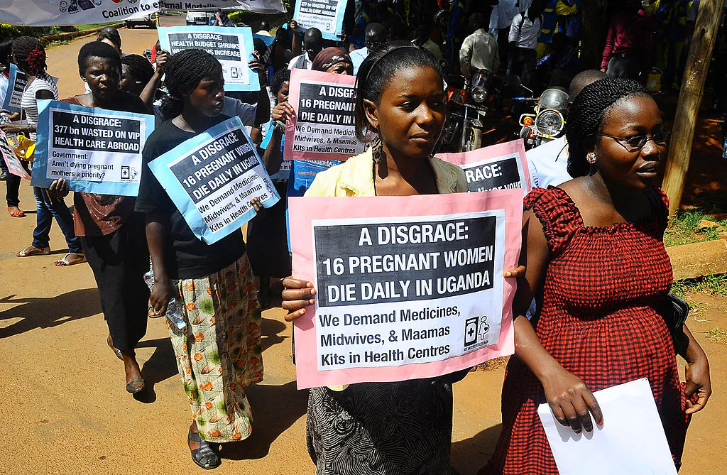 Activists carry placards outside the Constitutional court during a peaceful march in the capital Kampla on May 22, 2012 to protest the delay by a Ugandan court to deliver a ruling in a landmark lawsuit regarding the cases of two women who unattended bled to death while giving birth in Ugandan hospitals. (Isaac Kasamami/AP Photo)