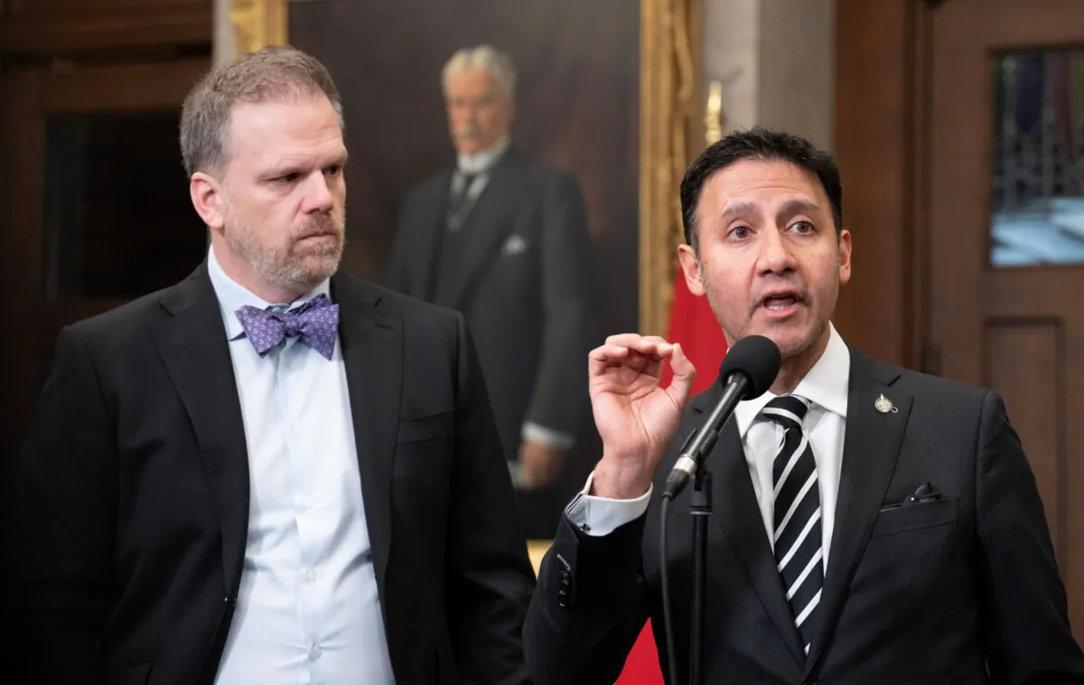 Health Minister Mark Holland (L) looks on as Justice Minister and Attorney General of Canada Arif Virani speaks at a press conference in Ottawa on Feb. 1, 2024. (The Canadian Press/Adrian Wyld)