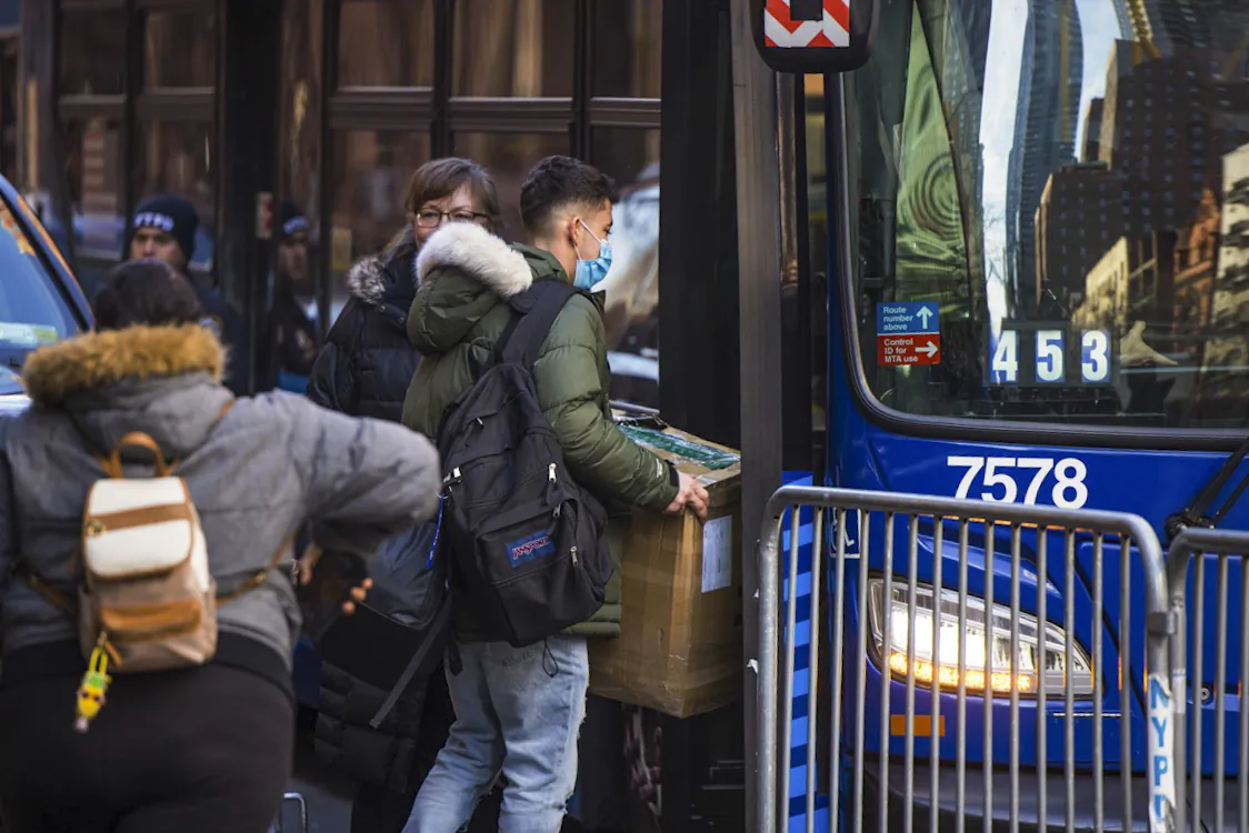  Illegal immigrants carry their belongings to a bus after accepting relocation after being evicted from the Watson Hotel, in New York, on Jan. 30, 2023. (Michael M. Santiago/Getty Images)