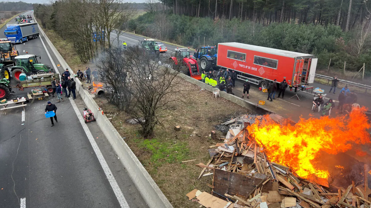 Farmers use their tractors to block a highway near the border with the Netherlands as they protest over price pressures, taxes and green regulation, in Arendonk, Belgium, on Feb. 2, 2024. (Christian Levaux/Reuters)