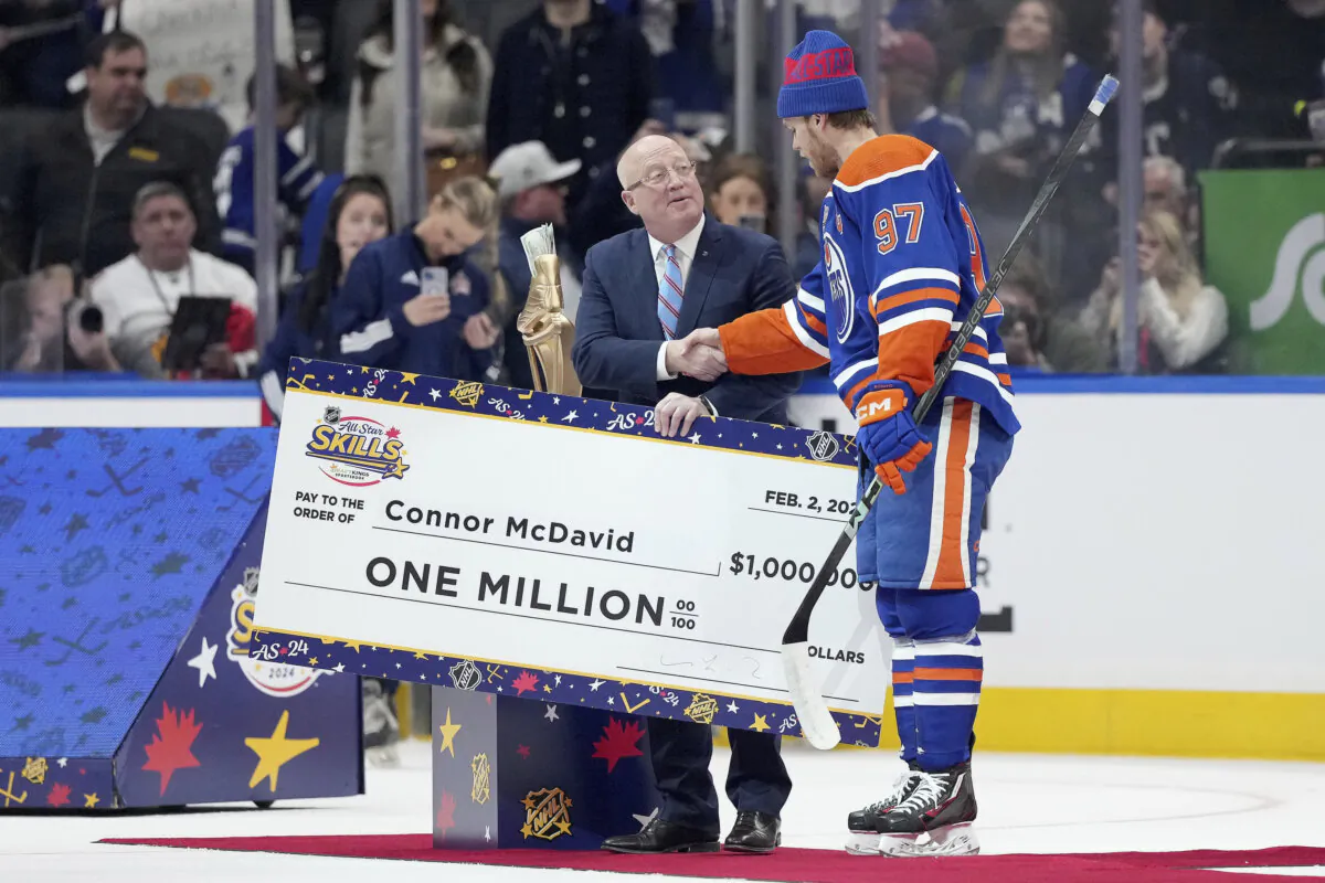 Edmonton Oilers' Connor McDavid (97) is presented with an oversized check for $ 1 million after winning the NHL All-Star hockey skills competition in Toronto on Feb. 2, 2024. (Nathan Denette/The Canadian Press via AP)