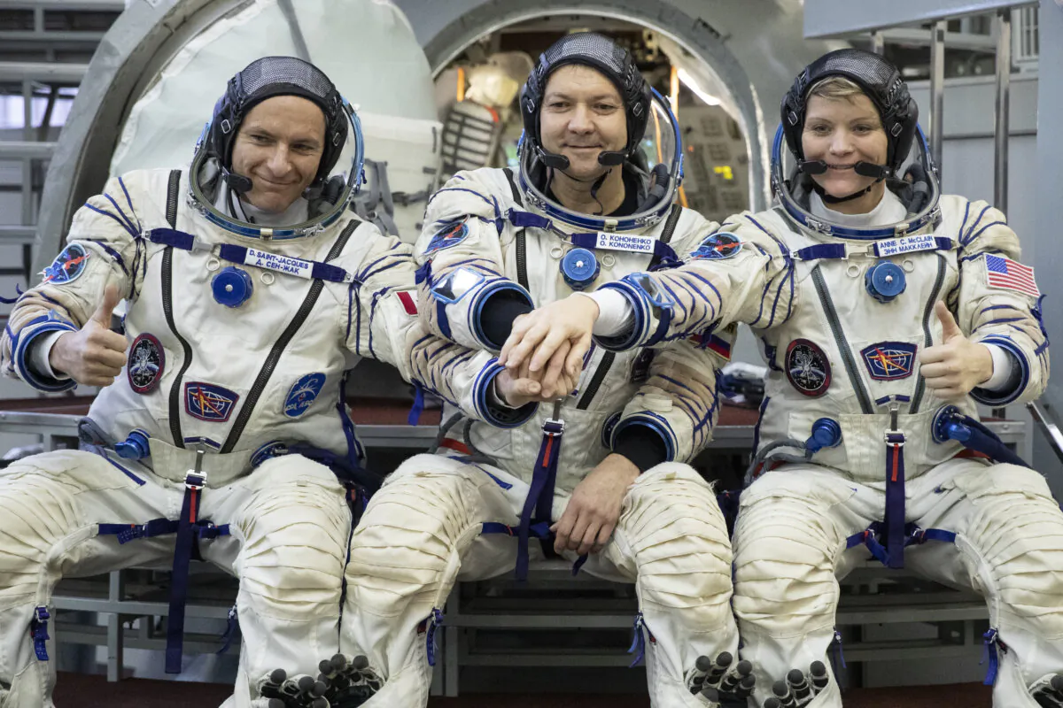 From left: CSA astronaut David Saint Jacques, Russian cosmonaut Оleg Kononenko‎ and U.S. astronaut Anne McClain pose for a photo before their final preflight practical examination in a mock-up of a Soyuz space craft at Russian Space Training Center in Star City, outside Moscow, Russia, on Nov. 14, 2018. (Pavel Golovkin/AP Photo, File)