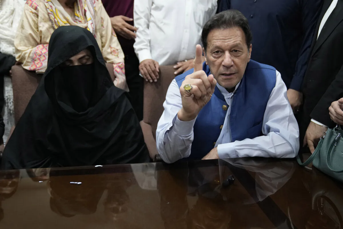 Pakistan's former Prime Minister Imran Khan, right, and Bushra Bibi,his wife, speak to the media before signing documents to submit surety bond over his bails in different cases, at an office of Lahore High Court in Lahore, Pakistan, on July 17, 2023. (K.M. Chaudary/AP Photo, File))