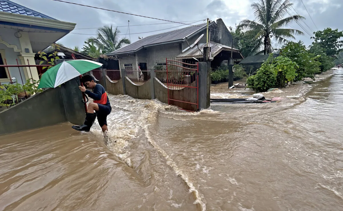A man wades through floodwaters brought about by heavy rains at a residential neighbourhood in Propseridad town, Agusan del Sur Province on southern Mindanao island on Feb. 1, 2024. (Erwin Mascarinas/AFP via Getty Images)