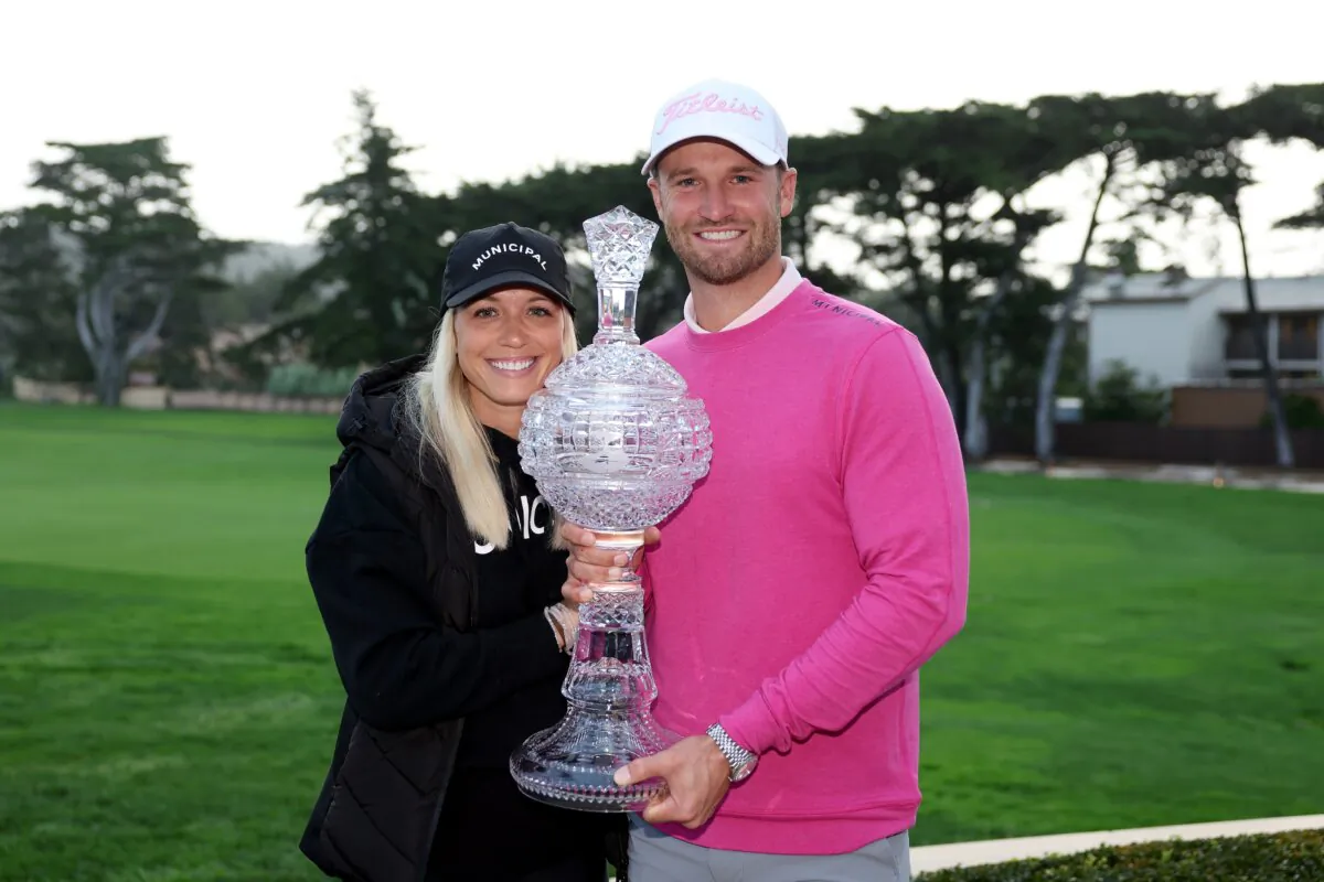 Wyndham Clark of the United States poses with the trophy and his girlfriend, Alicia Bogdanski, after winning the Pebble Beach Pro-Am in Pebble Beach, Calif., on Feb. 5, 2024. (Ezra Shaw/Getty Images)
