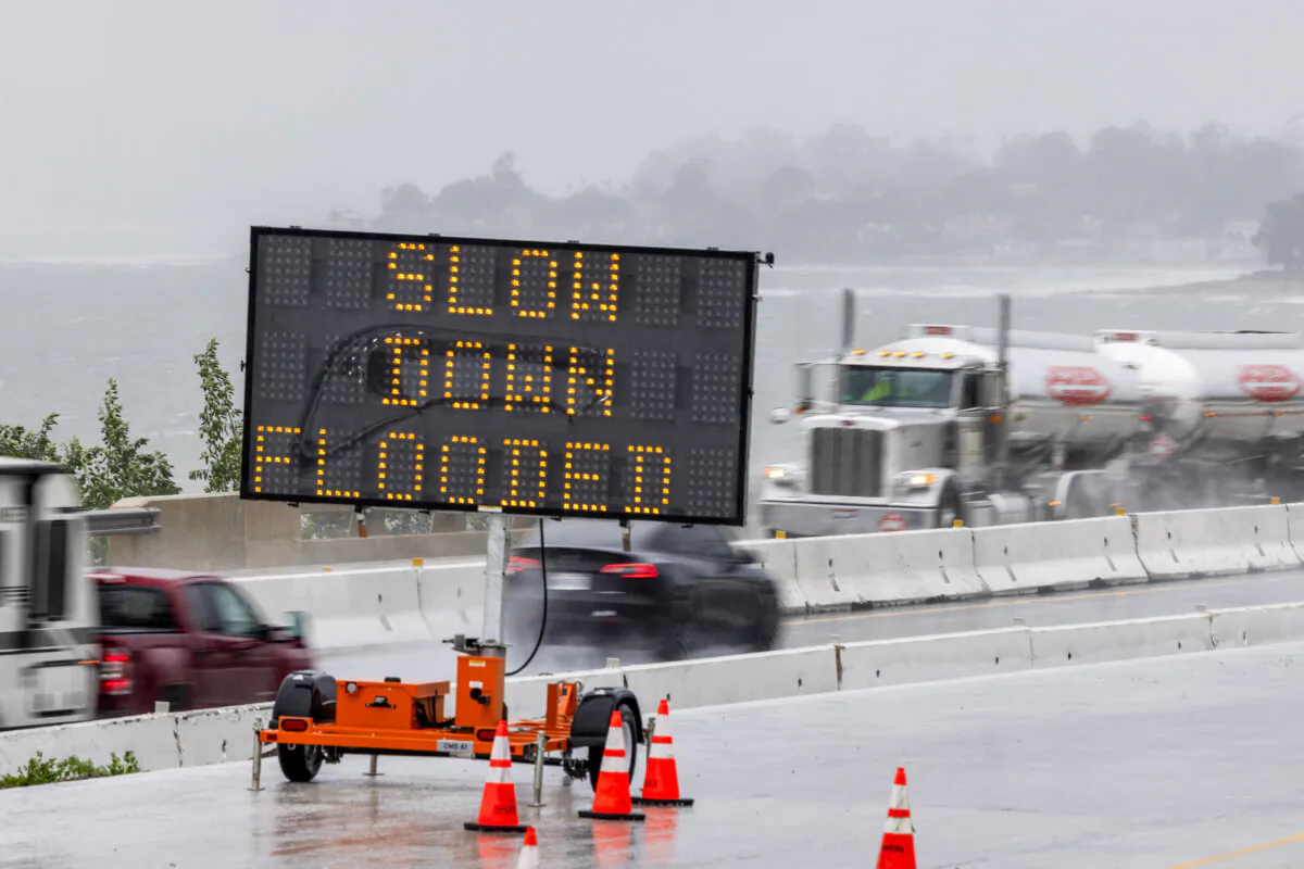 Signage in a road construction area on the 101 freeway warns of flooding as the second and more powerful of two atmospheric river storms, arrives south of Santa Barbara, California, on February 4, 2024. The US West Coast was getting drenched on February 1 as the first of two powerful storms moved in, part of a "Pineapple Express" weather pattern that was washing out roads and sparking flood warnings. The National Weather Service said "the largest storm of the season" would likely begin on February 4. (Photo by DAVID MCNEW / AFP) (Photo by DAVID MCNEW/AFP via Getty Images)