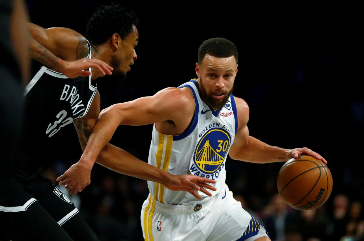 Golden State Warriors guard Stephen Curry (30) drives past Brooklyn Nets center Nic Claxton (33) during the first half of an NBA basketball game in New York on Feb. 5, 2024. (John Munson/AP Photo)