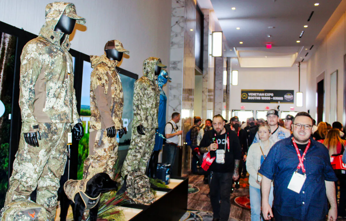 The National Shooting Sports Foundation's Shooting, Hunting, Outdoors Trade (SHOT) Show features more than just guns. Here, participants walk past a display of camouflage clothing at SHOT Show in Las Vegas, Nev., on Jan. 25, 2024. (Michael Clements/The Epoch Times)