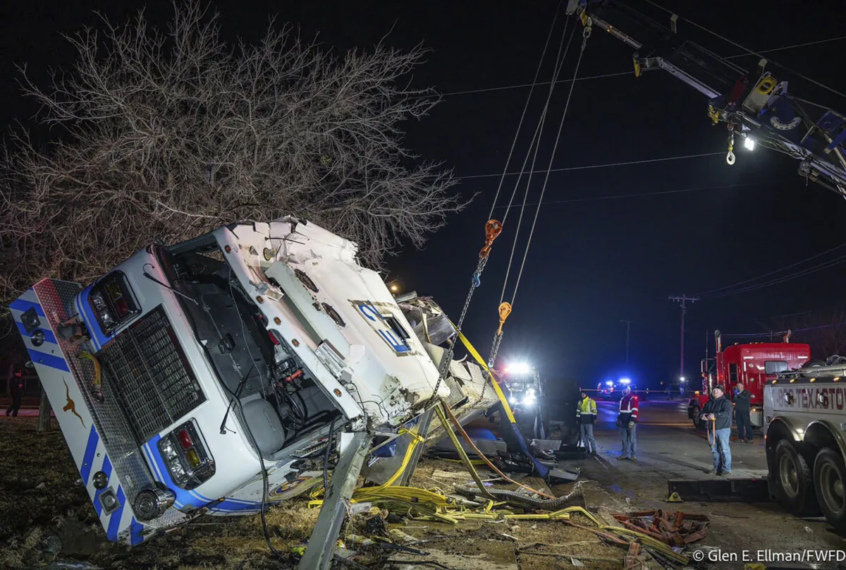 Emergency crews use a crane to lift a firetruck that rolled over and crashed while responding to a fire in Fort Worth, Texas, on Feb. 6, 2024. (Glen E. Ellman/Fort Worth Fire Department via AP)