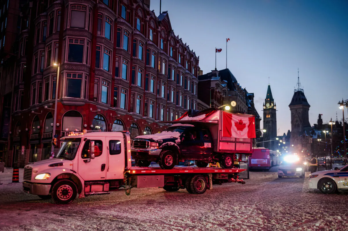 A flatbed removes a truck from the convoy after police cleared Wellington Street, previously occupied by the Freedom Convoy, in Ottawa on Feb. 19, 2022. (Andrej Ivanov/AFP via Getty Images)