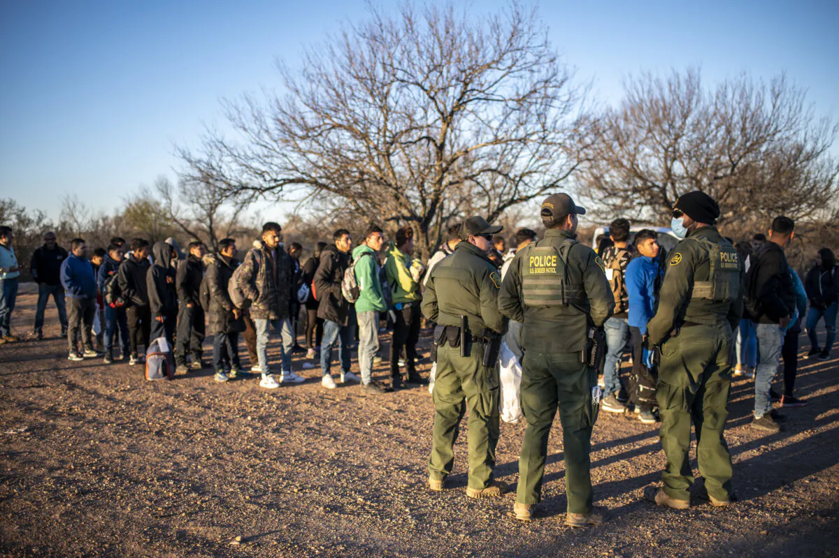 A group of immigrants who crossed the river illegally are processed by Border Patrol near the highway outside Eagle Pass, Texas, on Feb. 4, 2024. (SERGIO FLORES / AFP)