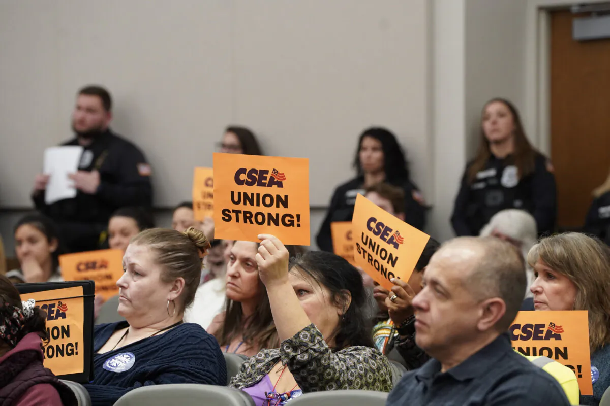 Orange County CSEA employers holding union signs during a county legislature meeting in Goshen, N.Y., on Feb. 1, 2024. (Cara Ding/The Epoch Times)