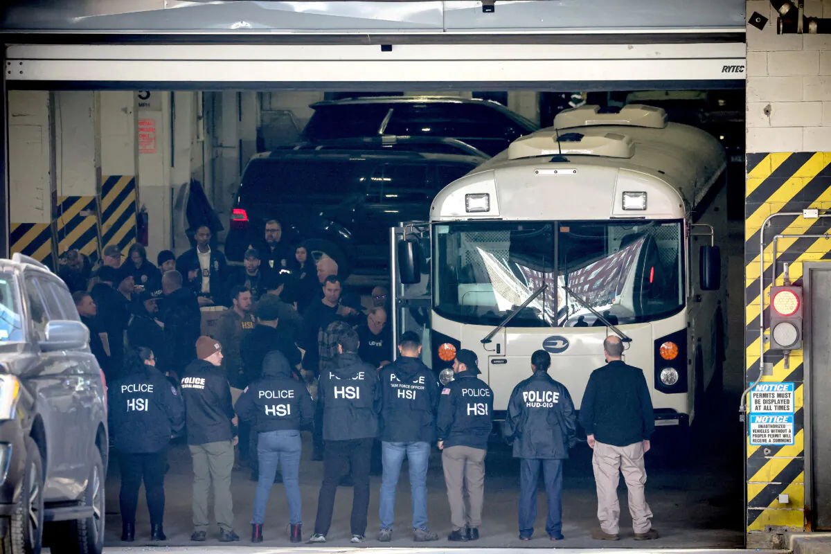 Members of Homeland Security Investigations and New York City Department of Investigation load people arrested on to a bus, after many current and former New York City Housing Authority (NYCHA) employees were charged with bribery and extortion offenses, in New York on Feb. 6, 2024. (Brendan McDermid/Reuters)