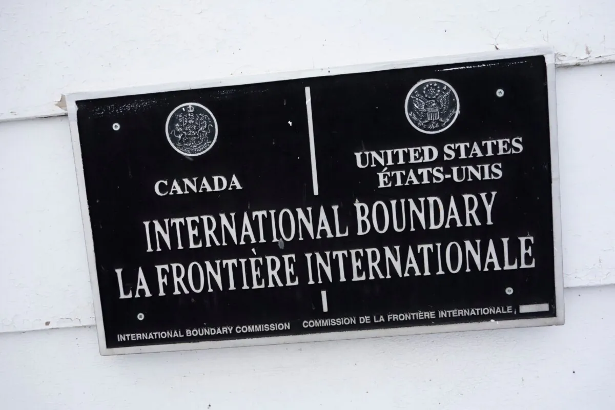 Illegal crossings from Canada into the U.S. are on the rise, prompting concerns about extremely lax border security and staffing limitations. A placard hangs on the side of a house in the border town of Pohenegamook, Quebec, on March 2, 2017. The U.S.-Canada border crosses through the middle of the house. (Don Emmert/AFP via Getty Images)