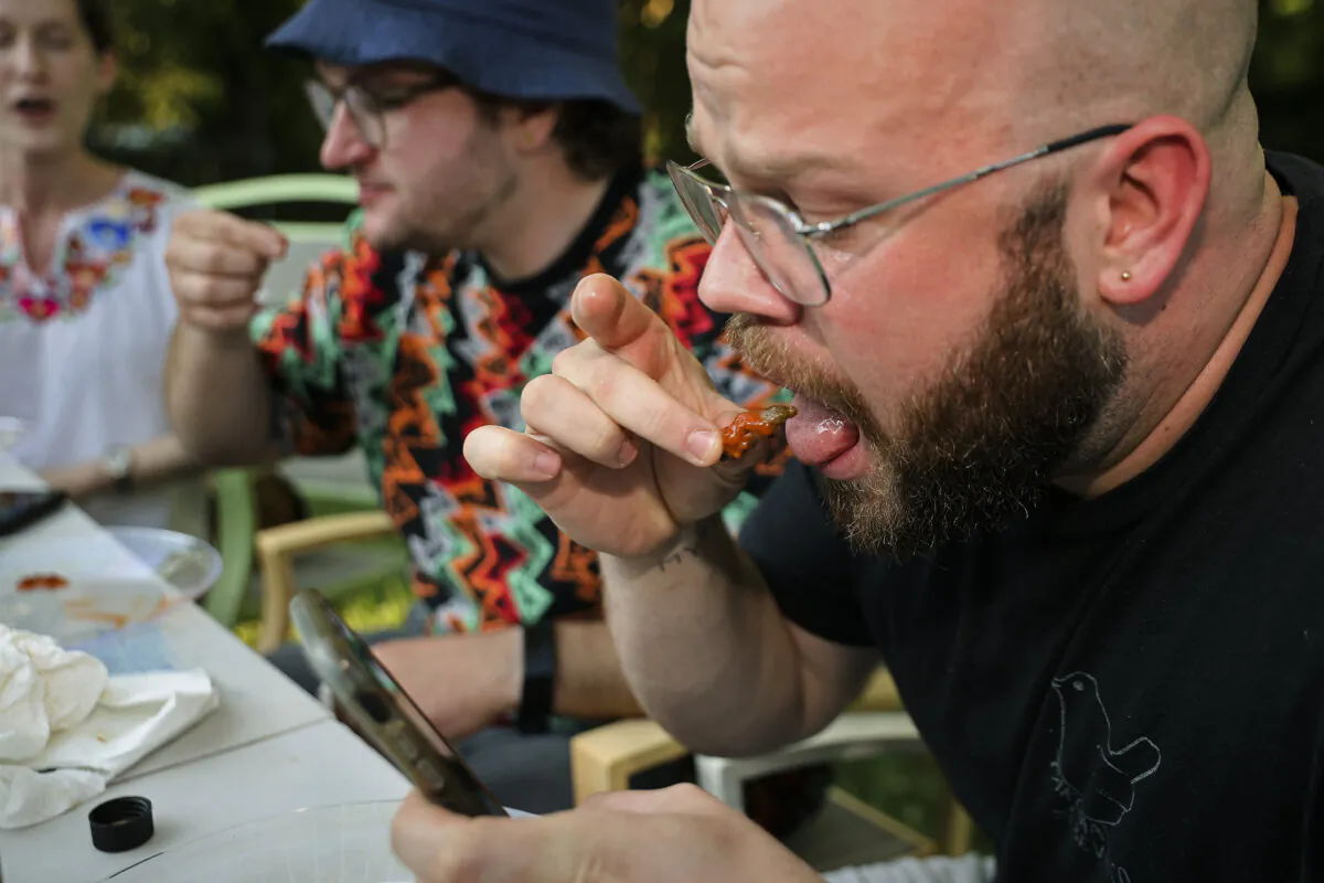 A group of friends eat pan-fried bugs as part of the Hot One's challenge, in Hyattsville, Maryland, on June 04, 2021. (Chip Somodevilla/Getty Images)