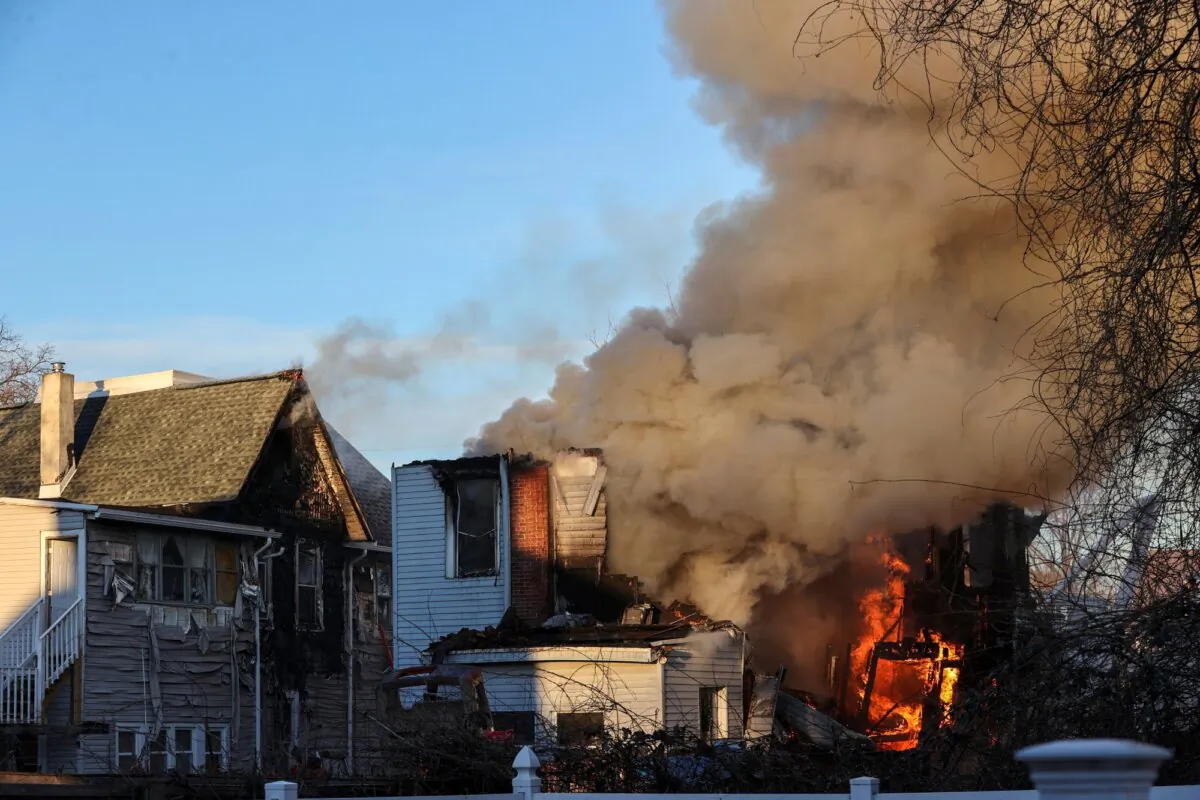 Firefighters work at the scene where two police officers were injured while responding to reported standoff in East Lansdowne, Pa., on Wednesday, Feb. 7, 2024. (AP Photo/Matt Rourke)