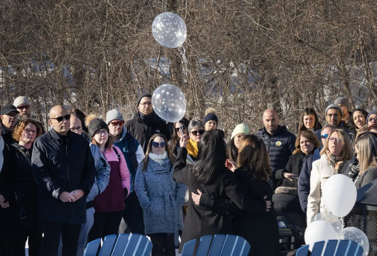 Two daycare employees release two balloons during a ceremony to commemorate the one year anniversary of the bus crash into a daycare that killed two children and injured six others, in Laval, Que., on Feb. 8, 2024. (The Canadian Press/Ryan Remiorz)