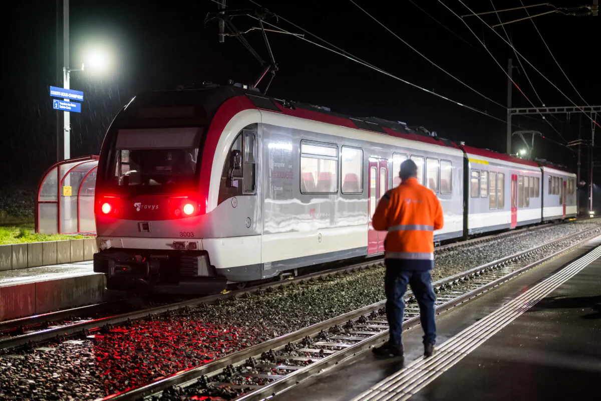 A railway technician stands next to a train, where passengers travelling from Yverdon to Sainte-Croix were earlier held hostage, in Essert-Sous-Champvent, western Switzerland, on Feb. 9, 2024. (Fabrice Coffrini/AFP via Getty Images)