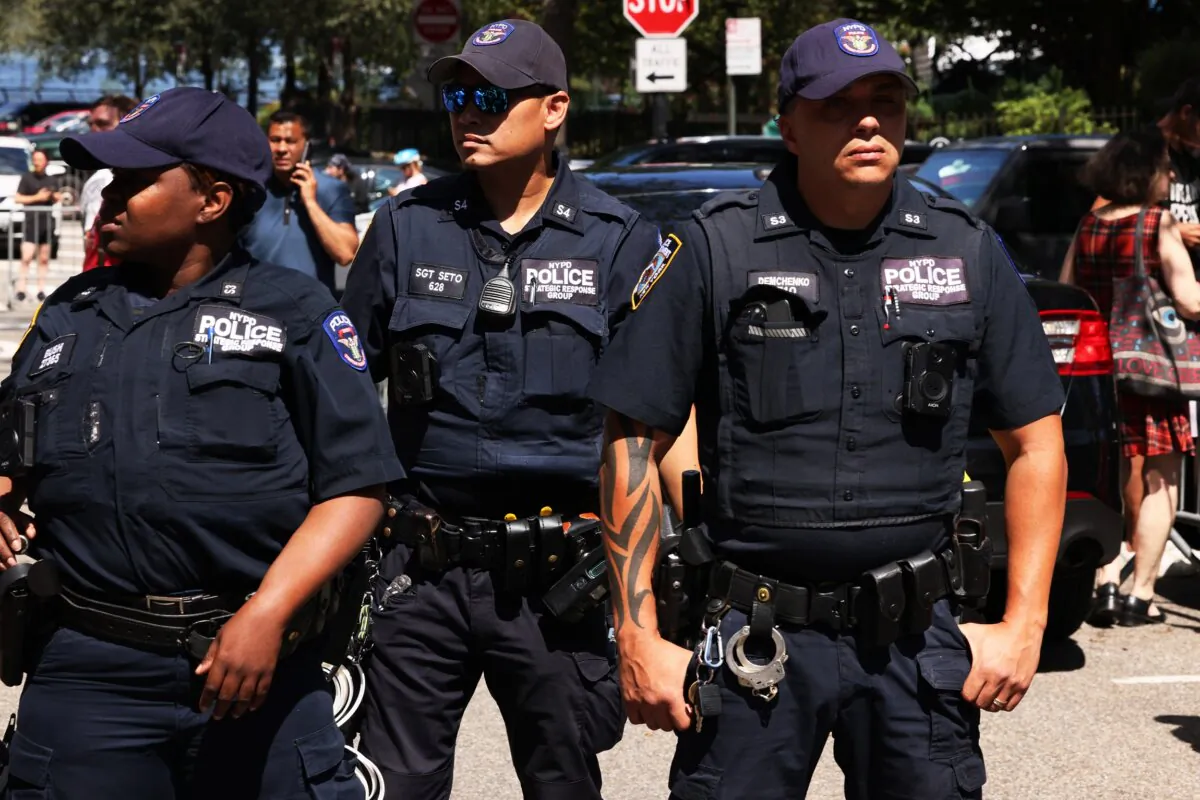 NYPD officers stand guard as people participate in an anti-migrant rally and protest outside of Gracie Mansion in New York on Aug. 27, 2023. (Michael M. Santiago/Getty Images)