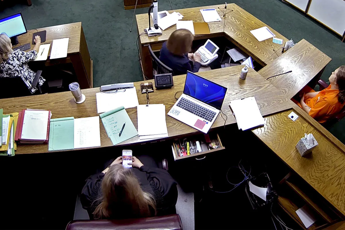 In this image from security camera video, Lincoln County District Judge Traci Soderstrom looks at her cellphone during a murder trial, at the Lincoln County District Court in Chandler, Okla., on June 12, 2023. (Lincoln County District Court/The Oklahoman via AP)