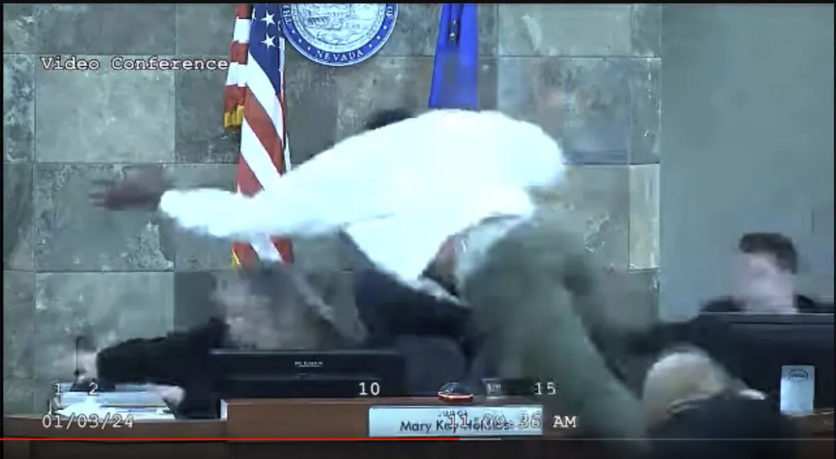 In this image from video provided by the Clark County District Court, a defendant identified by court officials and records as Deobra Redden is seen launching over the desk of Judge Mary Kay Holthus during his sentencing in a felony battery case on Wednesday, Jan. 3, 2024 in Las Vegas.  Redden has now been indicted by a grand jury for attempted murder Thursday, Feb. 8.. (Clark County District Court via AP)