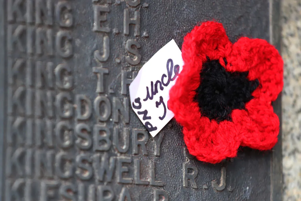 A handmade poppy is seen alongside a bronze plaque listing Australians who lost their lives in WWII on the undercroft of the State War Memorial in Kings Park in Perth, Australia, on April 25, 2020. (Paul Kane/Getty Images)