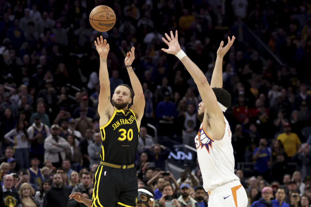 Golden State Warriors guard Stephen Curry (30) shoots a go-ahead basket against Phoenix Suns guard Devin Booker (R) during the second half of an NBA basketball game in San Francisco on Feb. 10, 2024. (Jed Jacobsohn/AP Photo)