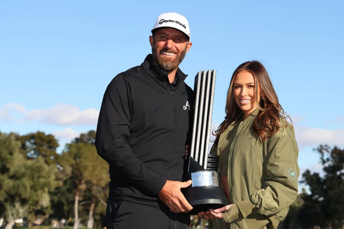 Captain Dustin Johnson of 4Aces GC poses with his wife Paulina Gretzky and the individual trophy after winning during day three of the LIV Golf Invitational–Las Vegas in Las Vegas on Feb. 10, 2024. (Michael Reaves/Getty Images)