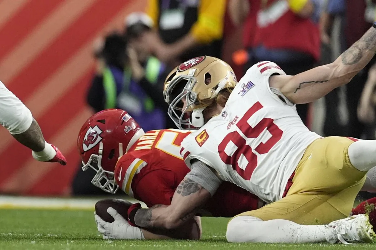Kansas City Chiefs defensive end George Karlaftis (56) recovers a fumble near San Francisco 49ers tight end George Kittle (85) during the first half of the Super Bowl in Las Vegas on Feb. 11, 2024. (AP Photo/George Walker IV)