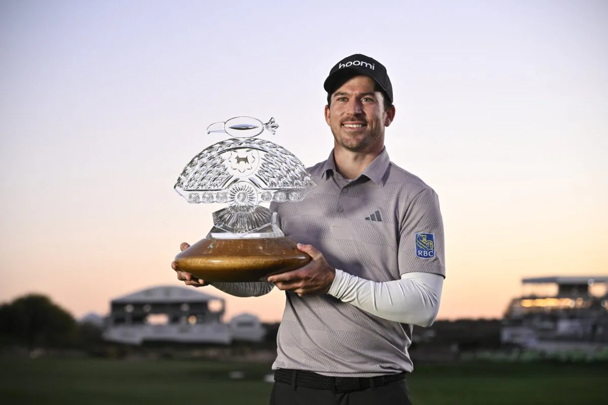 Nick Taylor of Canada celebrates with the trophy after winning in a two-hole playoff during the final round of the WM Phoenix Open at TPC Scottsdale in Scottsdale, Ariz., on Feb. 11, 2024. (Orlando Ramirez/Getty Images)