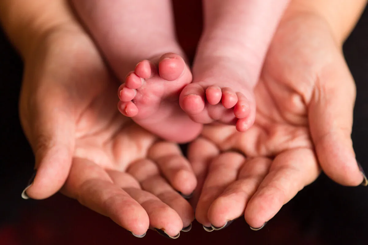 Image of a mother holding the feet of her baby on Jan. 23 2016. (Dominic Lipinski/PA Wire)