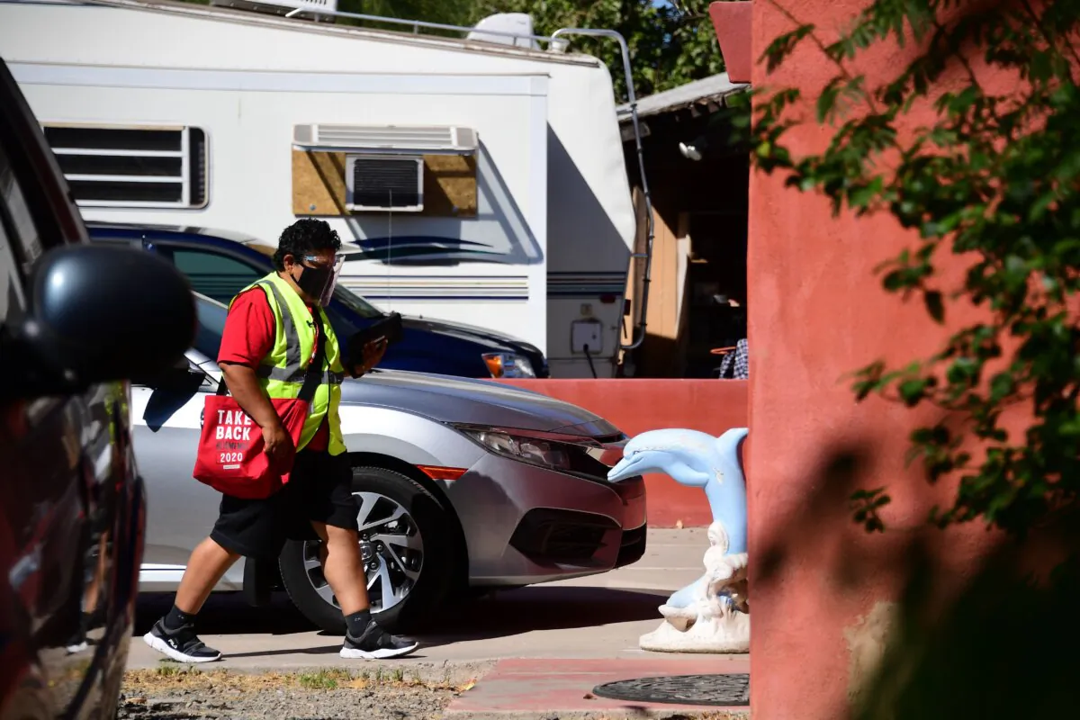 Armed with pro-Biden leaflets, a Democratic Party supporter canvasses the suburbs of Phoenix, Ariz., on Oct. 15, 2020. (Robyn Beck/AFP via Getty Images)