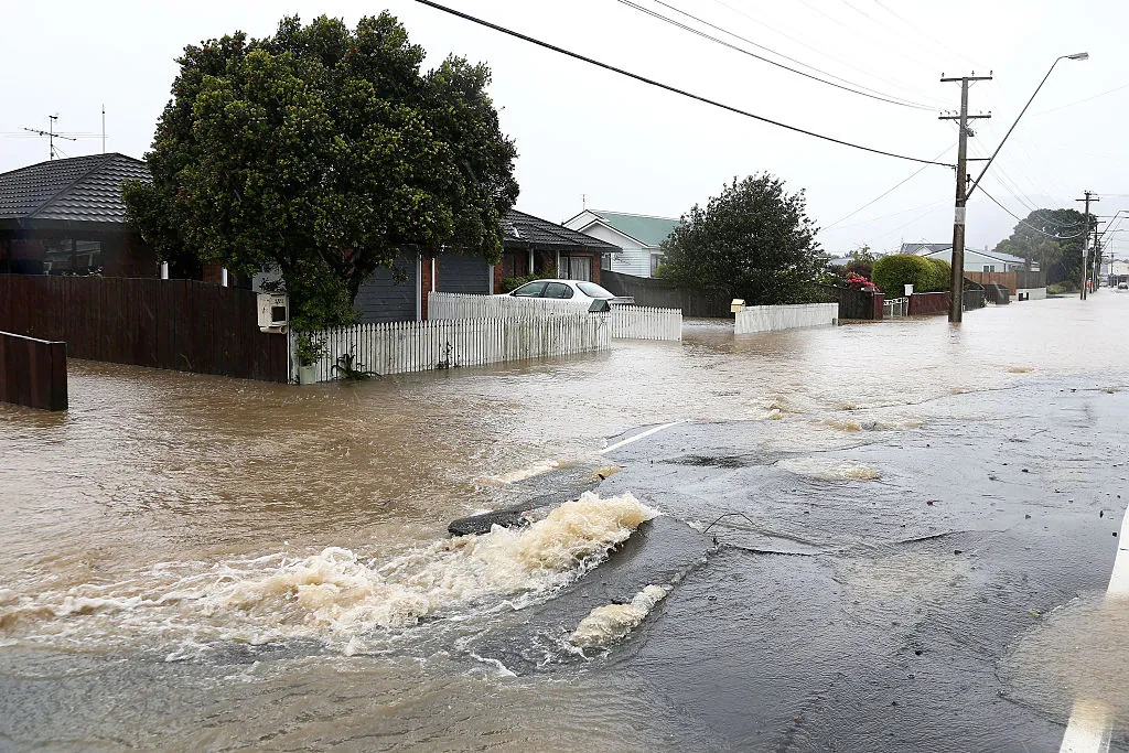Flood water flows through cracks in the road surface on Udy Street, Petone, after a bout of severe weather in Wellington, New Zealand, on Nov. 15, 2016. (Hagen Hopkins/Getty Images)