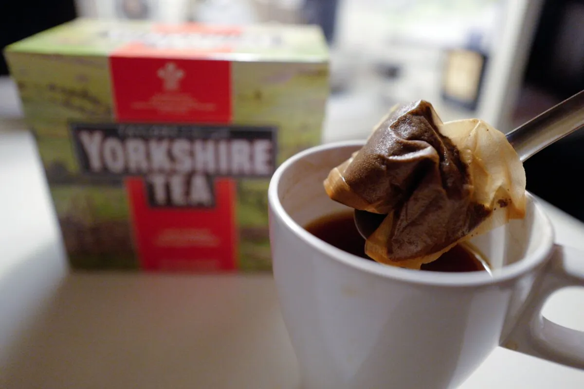 A man poses making a cup of tea with a Yorkshire Tea teabag with a box of tea in the background arranged as an illustration in London on Dec. 19, 2018. (Tolga Akmen/AFP via Getty Images)