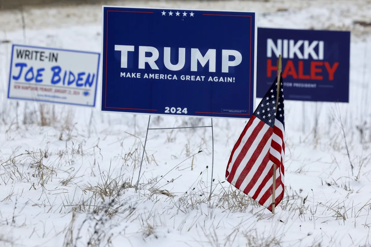 Campaign signs for Republican presidential candidates former President Donald Trump and former U.N. Ambassador Nikki Haley stand next to a sign asking voters to write in President Joe Biden in the upcoming primary in Loudon, N.H., on Jan. 19, 2024. (Chip Somodevilla/Getty Images)