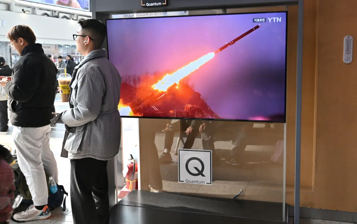 Two men stand next to a television screen showing a news broadcast with file footage of a North Korean missile test, at a railway station in Seoul on Feb. 2, 2024. (Jung Yeon-je/AFP via Getty Images)