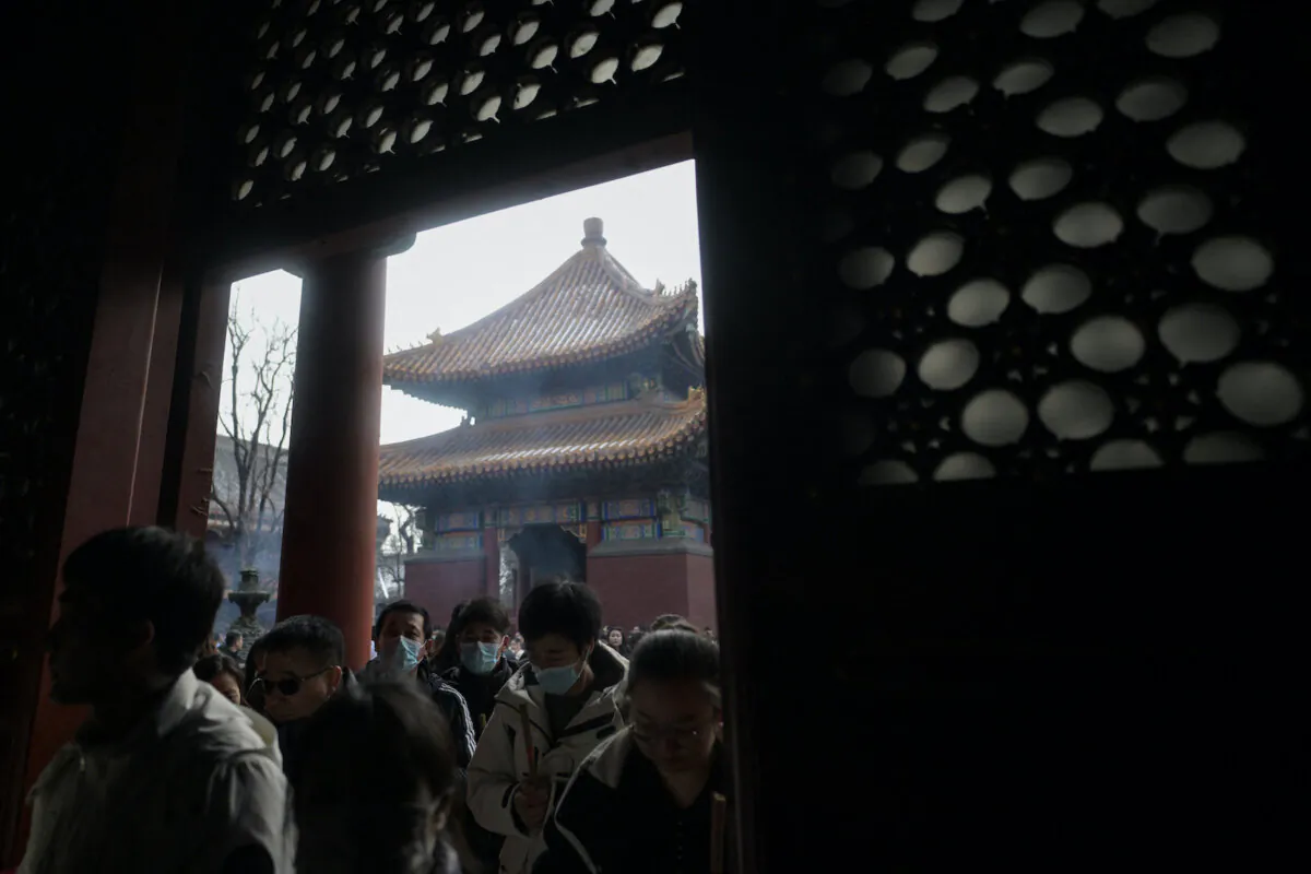 People gather to burn incense sticks and offer prayers at Yonghe Temple, also known as Lama Temple, on the first day of the new year in Beijing on Jan. 1, 2024. (Pedro Pardo/AFP via Getty Images)